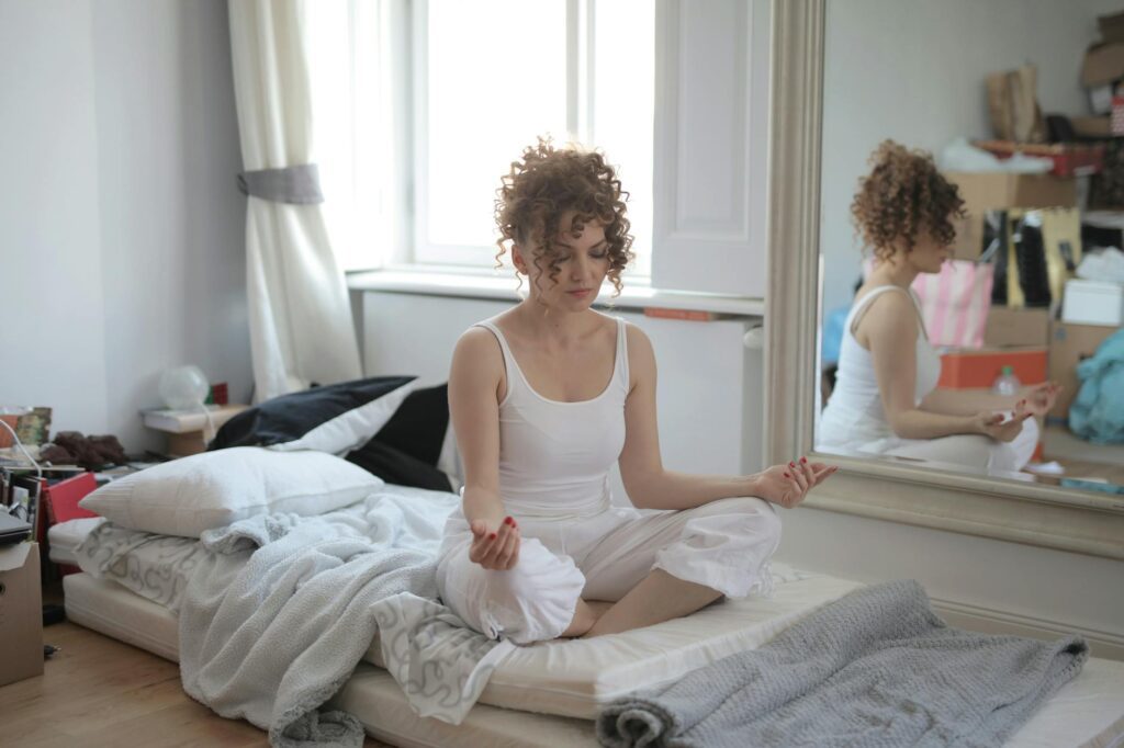 calm woman in lotus pose meditating after awakening at home