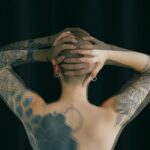 unrecognizable tattooed person on black background