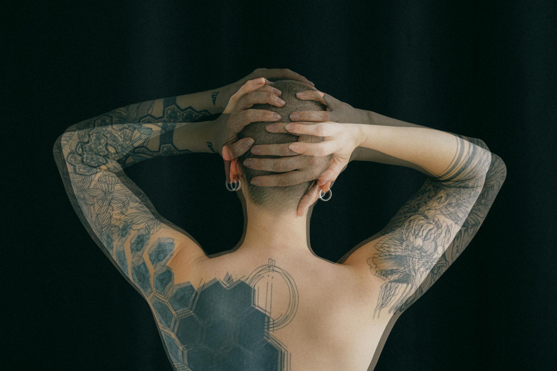 unrecognizable tattooed person on black background